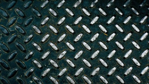 Detailed view of a diamond plate metal surface showcasing its rugged pattern.
