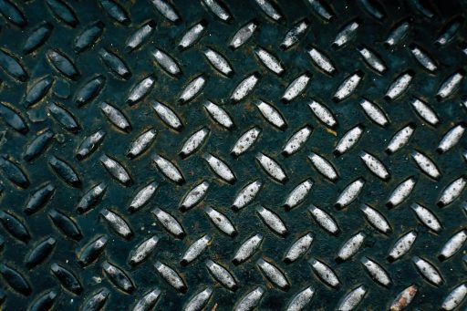 Detailed view of a diamond plate metal surface showcasing its rugged pattern.