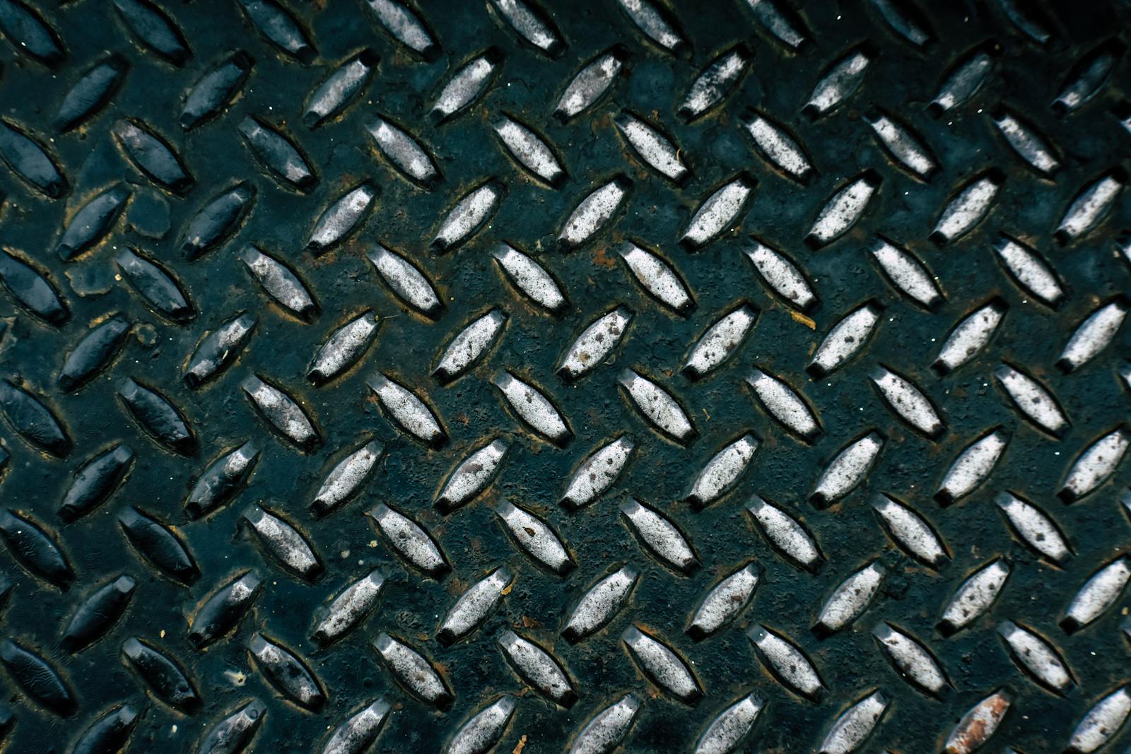 Detailed view of a diamond plate metal surface showcasing its rugged pattern.
