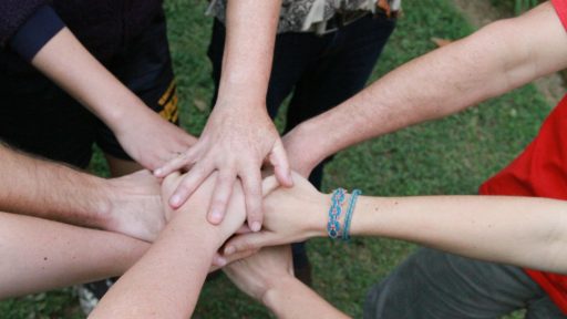 a group of people putting their hands together