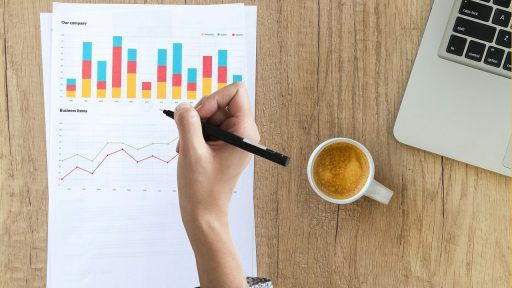 Twee zakenmensen bekijken financiële documenten aan een vergadertafel als voorbereiding op een bedrijfsovername