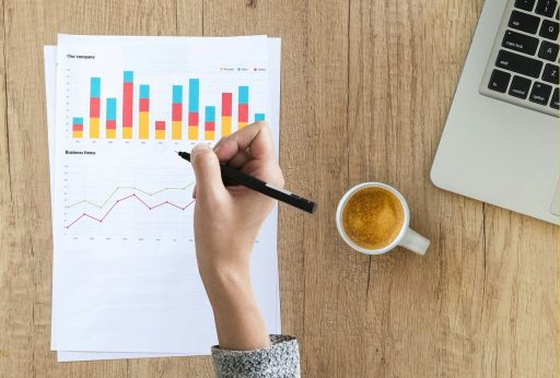 Twee zakenmensen bekijken financiële documenten aan een vergadertafel als voorbereiding op een bedrijfsovername