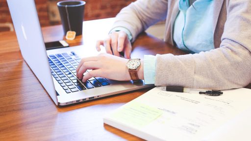 Werkende professional studeert op laptop voor een HRM-opleiding naast werk