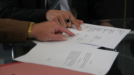 Twee personen bespreken een arbeidscontract aan een kantoorvtafel