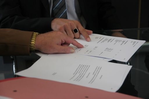 Twee personen bespreken een arbeidscontract aan een kantoorvtafel