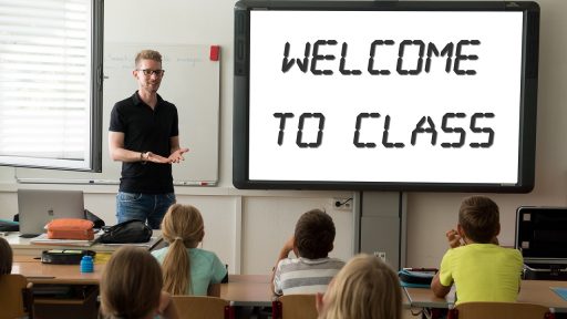 Een leraar staat voor een whiteboard in een klaslokaal