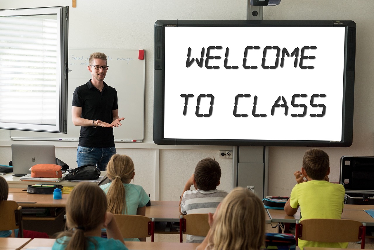 Een leraar staat voor een whiteboard in een klaslokaal