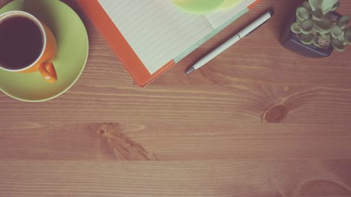 Zzp'er die zijn uurtarief herberekent achter een bureau met een laptop en notitieboek