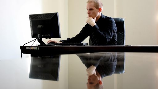 Ondernemer die nadenkend achter zijn bureau zit met aantekeningen voor hem