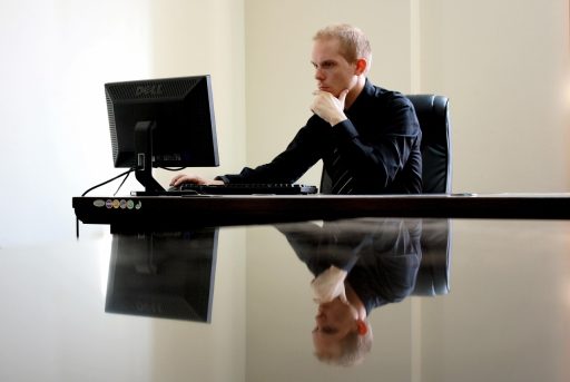 Ondernemer die nadenkend achter zijn bureau zit met aantekeningen voor hem