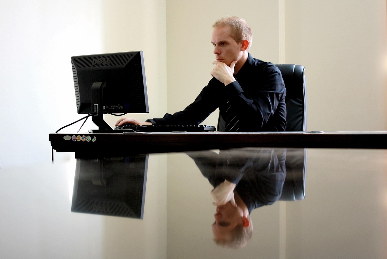 Ondernemer die nadenkend achter zijn bureau zit met aantekeningen voor hem