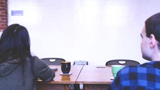 Teamleden bespreken betekenis van begrippen op een whiteboard tijdens een managementoverleg