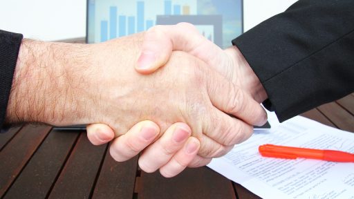 Ondernemer die een financieel contract doorleest aan bureau
