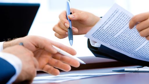 Ondernemer die personeelsdocumenten en arbeidscontracten doorneemt aan een bureau